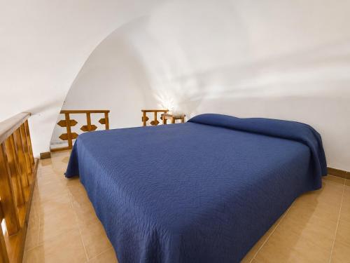 a bedroom with a blue bed in a room at Dammuso Ziloto - Cala Levante & Arco dell'Elefante in Pantelleria