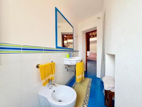 a bathroom with a sink and a toilet and a mirror at Dammuso Ziloto - Cala Levante & Arco dell'Elefante in Pantelleria