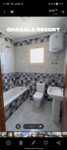 a bathroom with a tub and a toilet and a sink at Ghazala resort in Marsa Matruh