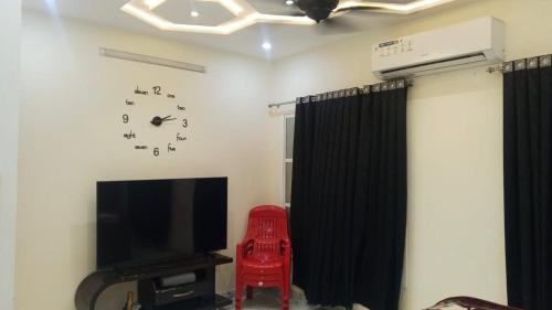 a living room with a television and a red chair at HD Smart Hotel in Kot Mergulla