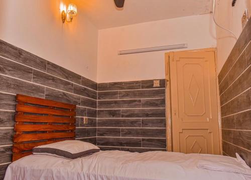a bedroom with a bed and a brick wall at HD Smart Hotel in Kot Mergulla