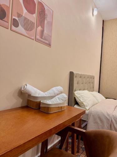 a hotel room with a table and a bed at Pousada Nhá Luz in Salesópolis