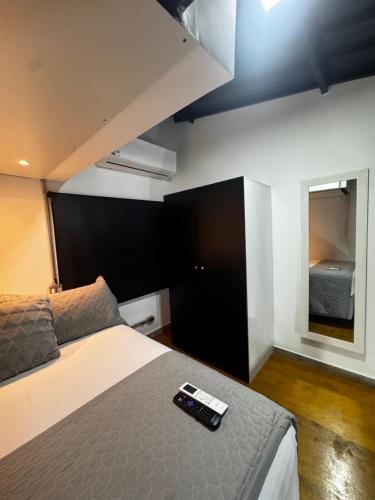 a bedroom with a bed with a remote control on it at Village Conti Ideal para casal com Ar C01 in Campinas