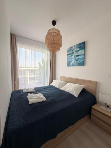 a bedroom with a blue bed and a window at Waterfront studio in Balatonszemes
