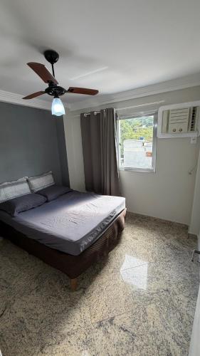 a bedroom with a bed with a ceiling fan at Cobertura de Frente Para o Mar e Piscina Village das Ondas in Piúma