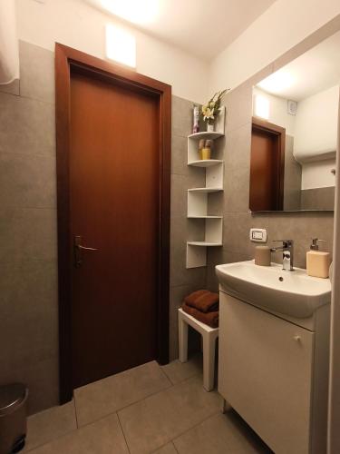 a bathroom with a sink and a brown door at Calin Apartment in Turin