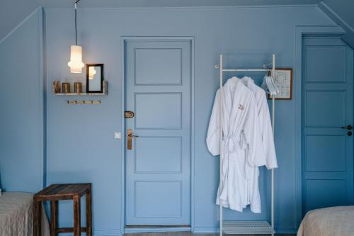 a white robe hanging on a door in a room at Hotel Villa Lejet in Tisvilde