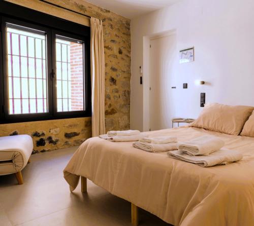 a bedroom with a bed with towels on it at Casa Aurora in Almoharín