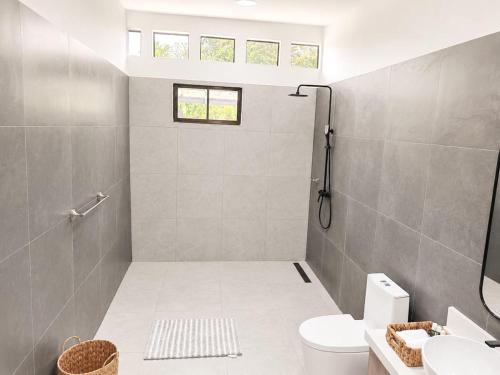 a bathroom with a shower and a toilet and a sink at Villa Isora in Talamanca