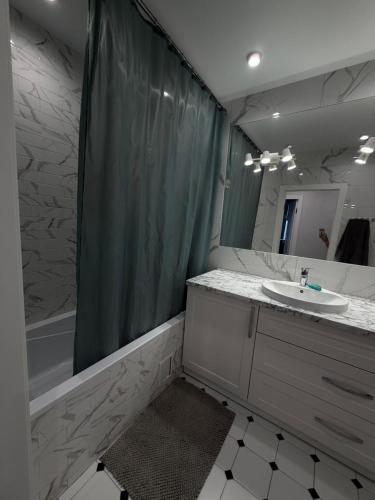 a bathroom with a sink and a shower curtain at 56 Жемчужина in Odesa