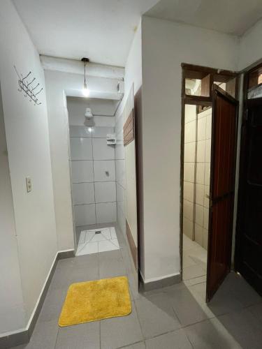 a bathroom with a shower and a yellow rug at Casa Agua Dulce in Samaipata