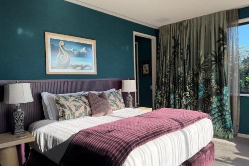 a bedroom with a bed and a blue wall at Tirohanga Nui in Oamaru