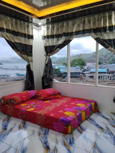 a bed in a room with a large window at Homestay SeAngel in Labuan Bajo