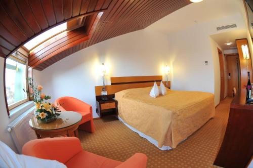 a hotel room with a bed and a table and chairs at Hotel Jasmine in Braşov