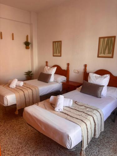 two beds in a hotel room with towels on them at Hostal Avenida Pozo Alcón in Pozo Alcón