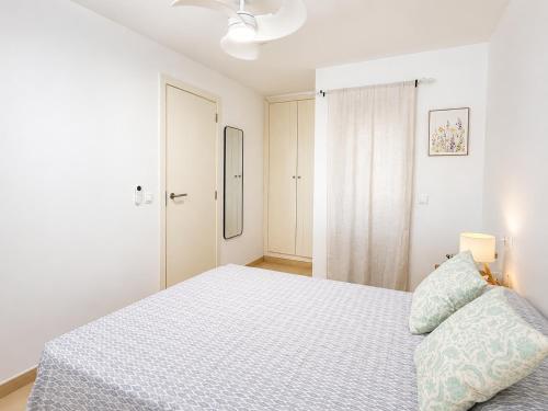 a white bedroom with a bed and a closet at Apartment with pool in Cala Millor in Cala Millor