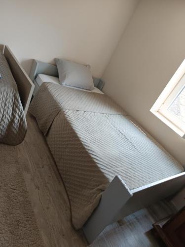 a bed in the corner of a room with a window at Appartement calme, emplacement stratégique, proche de toutes commodités, de l'autoroute, valenciennes, lille, Belgique, wifi, Netflix, parking Gratuits, lave linge, sèche linge in Raismes