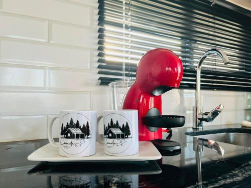 three coffee mugs on a tray on a kitchen counter at Carmela, Colonia Estrella in Carmelo
