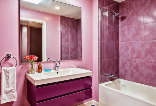 a pink bathroom with a sink and a tub at Hotel Volga EGG Grand Inn Near Delhi Airport in New Delhi
