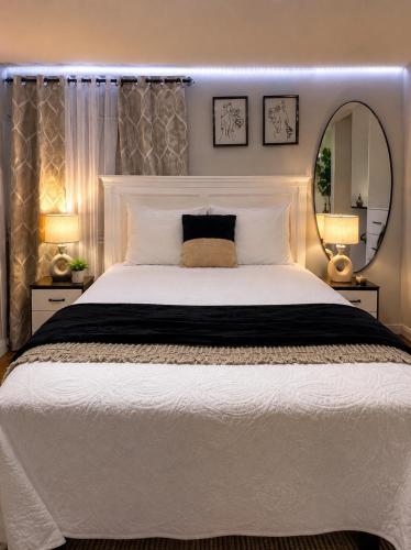 a bedroom with a large white bed and a mirror at Rosa Bella Comfort Suite in Homestead