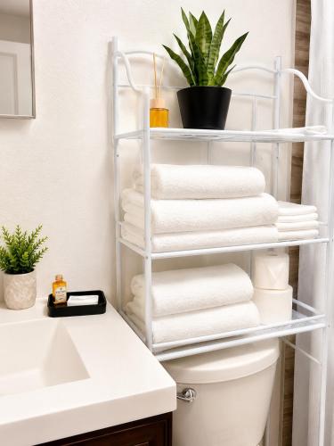 a bathroom with a rack of towels and a sink at Rosa Bella Comfort Suite in Homestead