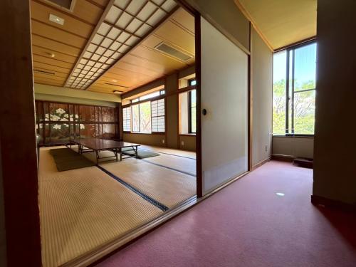 an empty room with a table and a glass door at パークホテル楽々園 in Maebashi