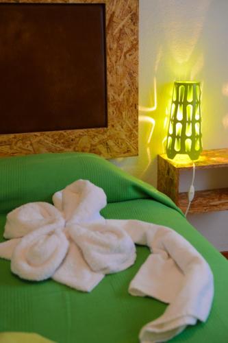 a green plate with towels on top of a bed at SEIA Apartamentos Serra da Estrela in Seia
