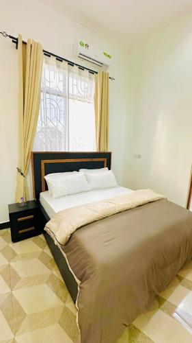 a large bed in a bedroom with a window at Uluguru Breeze in Morogoro