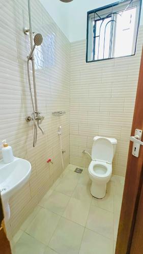a bathroom with a shower and a toilet and a sink at Uluguru Breeze in Morogoro