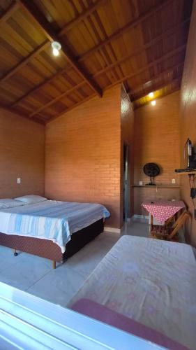 a bedroom with two beds and a table in it at Recanto Raios do Sol in Caldas