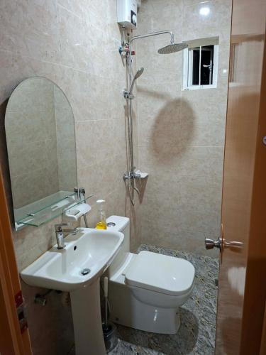 ein Badezimmer mit weißer Toilette und Waschbecken in der Unterkunft Brians Palace in Tagum
