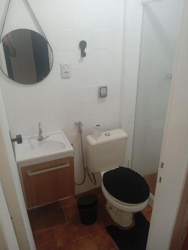 a bathroom with a toilet and a sink and a mirror at Studio Royal Trianon Centro in Campos dos Goytacazes