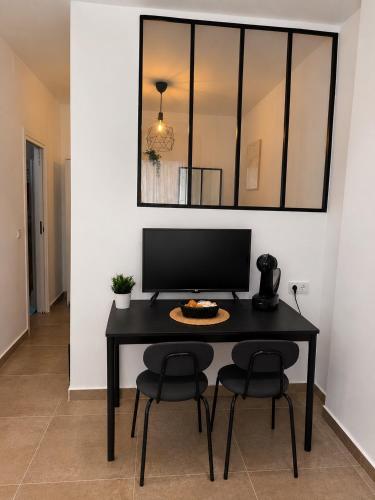 a black table with two chairs and a computer on it at Andalucía Suites in Almería