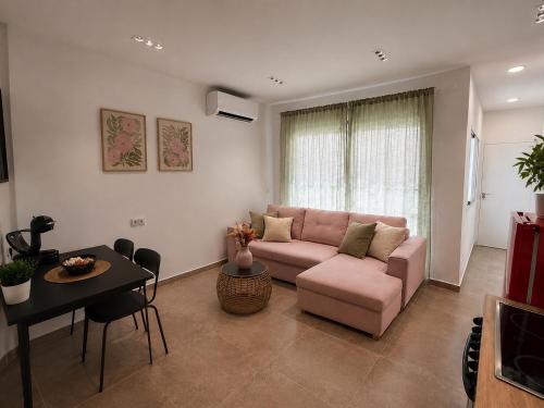 a living room with a pink couch and a table at Andalucía Suites in Almería