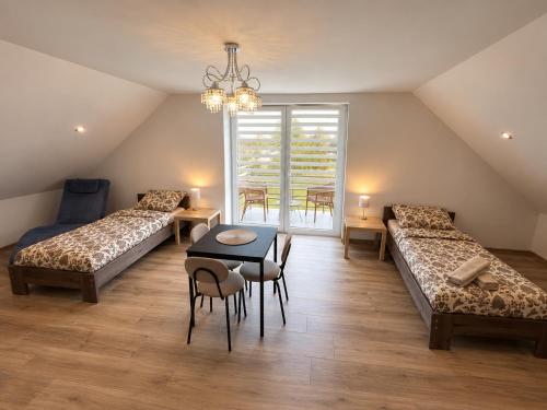 a room with two beds and a table and chairs at Aura Poręba Żegoty in Poręba Żegoty