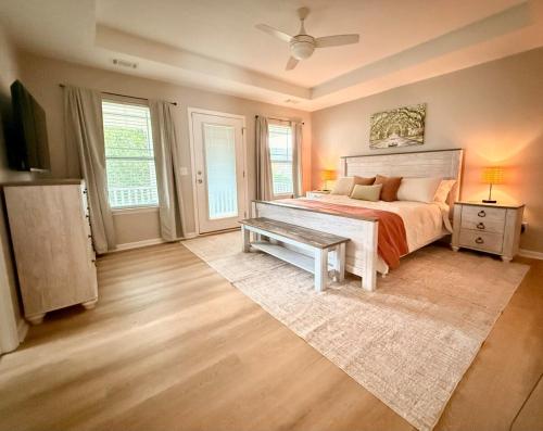 a bedroom with a bed and a table and windows at Fenced Yard, Pool, Lazy River SAV Area Oasis! in Savannah