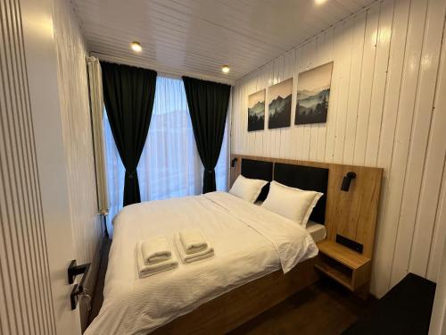a small bedroom with a white bed with a window at Container House Zakani in Zak'at'kari