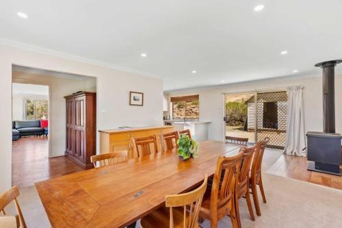 a kitchen and dining room with a wooden table and chairs at Davali at Mogo in Mogo