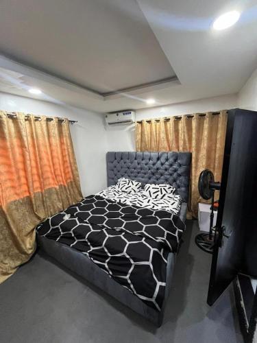 a bedroom with a bed in a room with curtains at ParamountLuxe 4 bedroom duplex in Ikeja in Ikeja