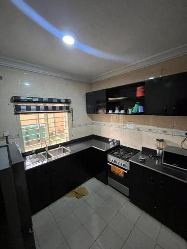 a kitchen with a sink and a stove top oven at ParamountLuxe 4 bedroom duplex in Ikeja in Ikeja