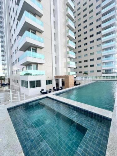 a swimming pool in front of some tall buildings at Studio Design 305 in Sobral