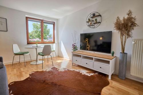 a living room with a flat screen tv and a table at FeWo Alte Mainbrücke in Würzburg