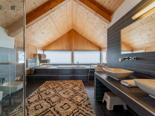 a bathroom with two sinks and a bath tub at Tauern Lodge in Hohentauern
