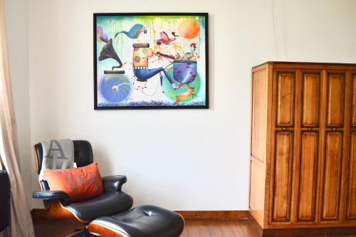 a room with a chair and a picture on the wall at B&B Petit-Hallet in Hannut