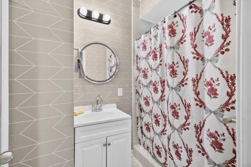 a bathroom with a shower curtain and a sink at Sunshine Cozy Crib in Glenarden