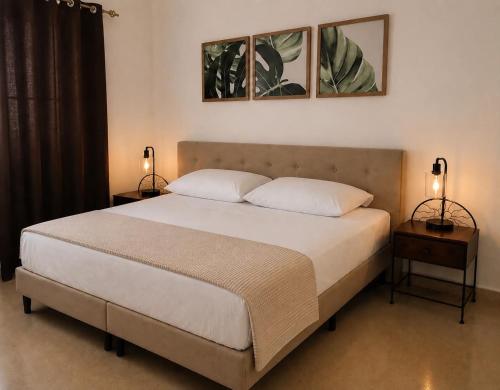 a bedroom with a large bed with two lamps at Airhome free shuttle in Panama City