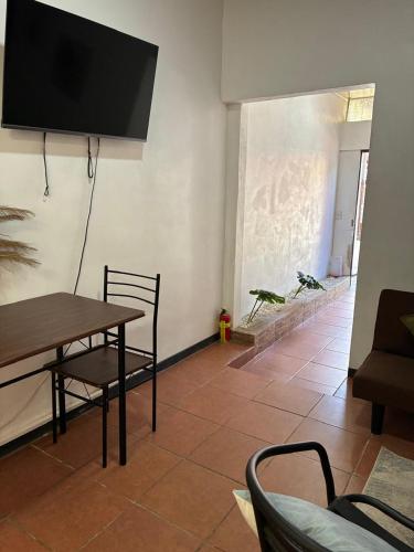 a living room with a table and a tv on the wall at Buganvilla Quepos No 2 Aire acondicionado in Quepos