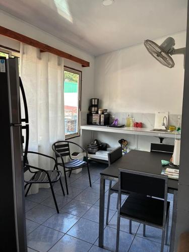 a kitchen with a table and chairs in a room at Buganvilla No 3 Aire Acondicionado in Quepos