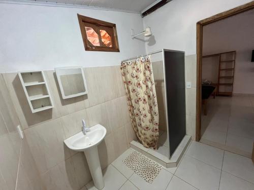 a bathroom with a sink and a shower at Pousada Fanticelli in Nova Viçosa