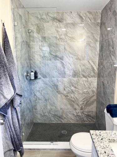 a bathroom with a shower with a toilet at Palm Beach Cottage in West Palm Beach